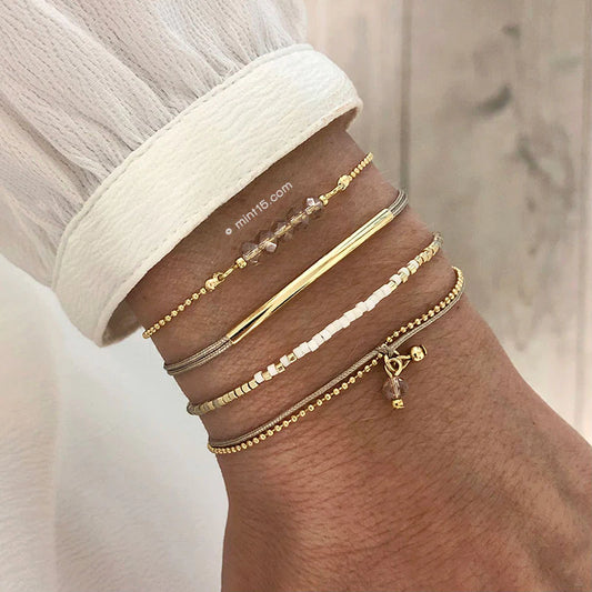 Armbanden set white & natural, goudkleurig, maat 16-19cm, om de arm van een vrouwelijk model